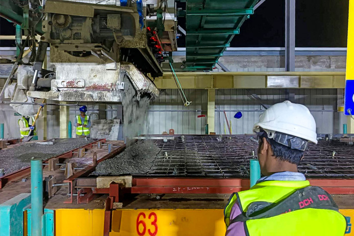 Concrete distributor pouring concrete into wall panel moulds